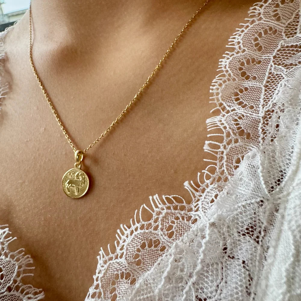 Gold pendant necklace featuring a detailed charm, perfect for women seeking a classic and minimalist accessory.