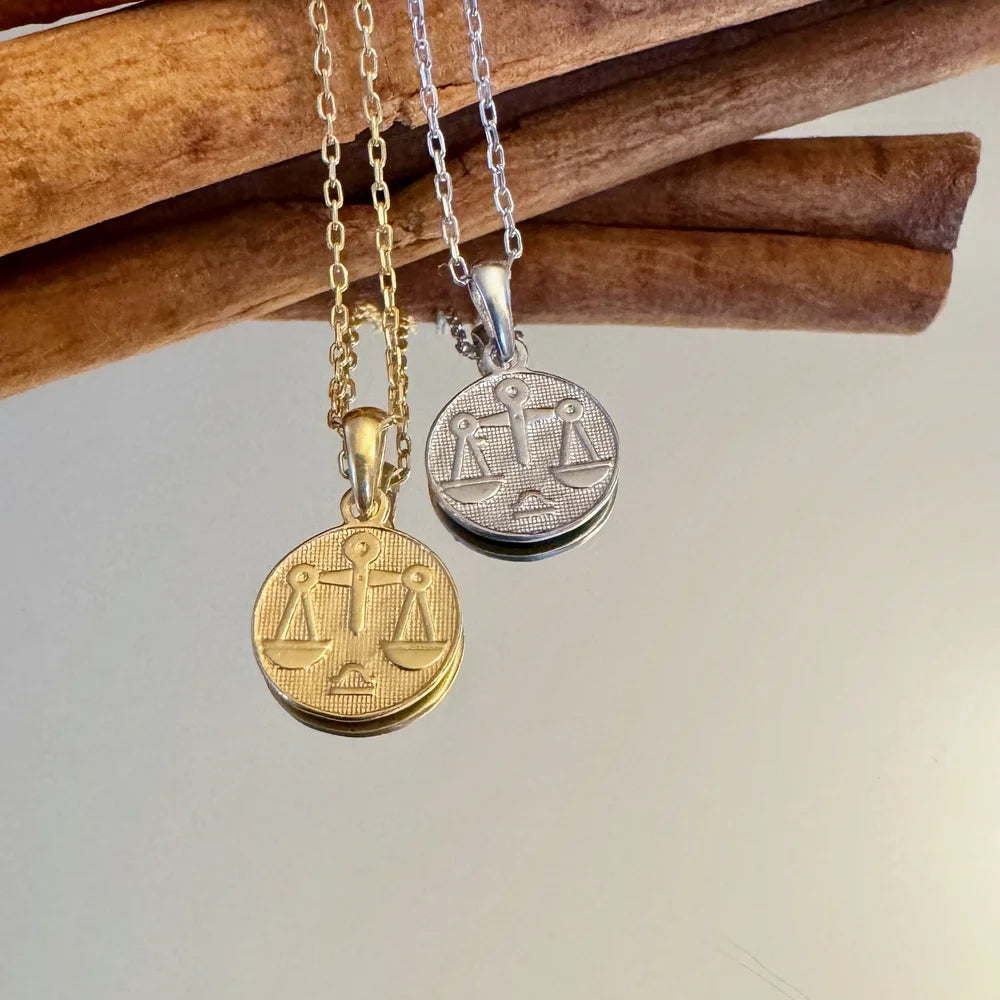 Stylish gold and silver balance scale pendants on chain, perfect for unisex wear and minimalist occasions.
