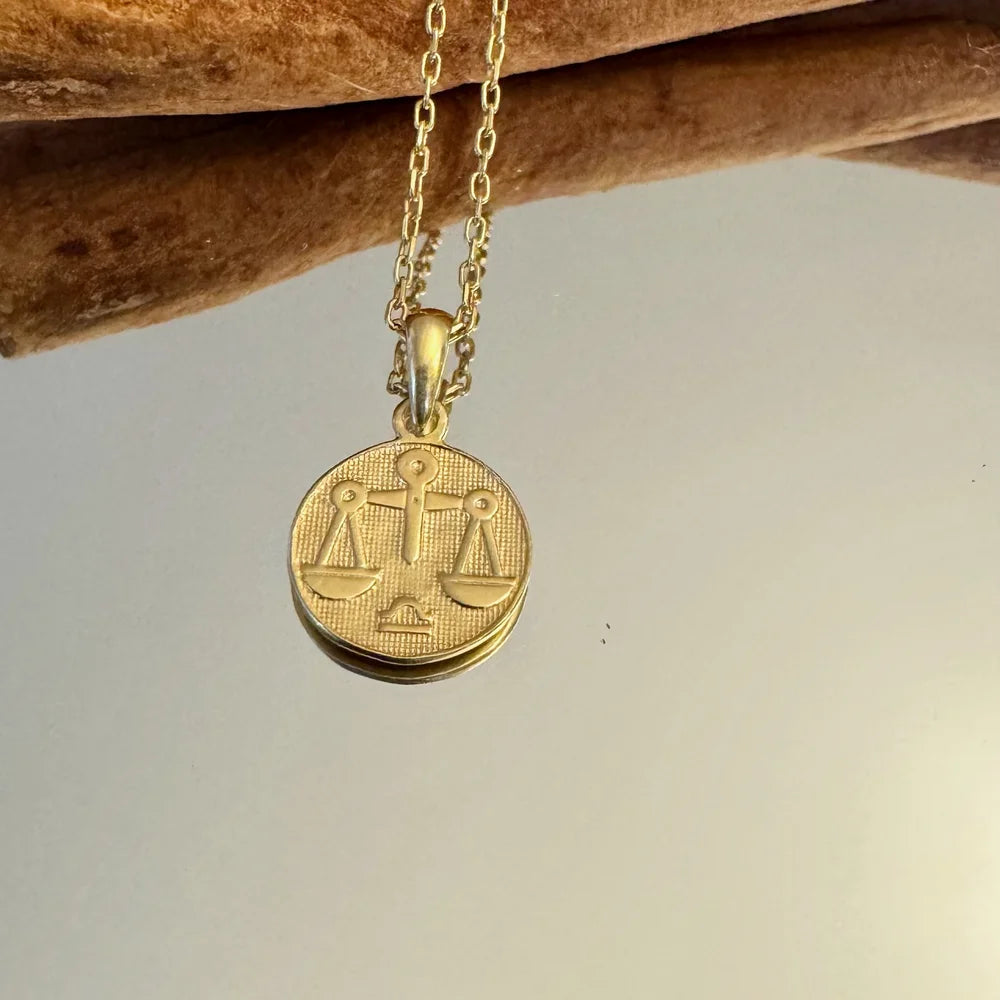 Gold Libra pendant necklace with intricate balance scales, perfect for women seeking a unique, minimalist accessory.