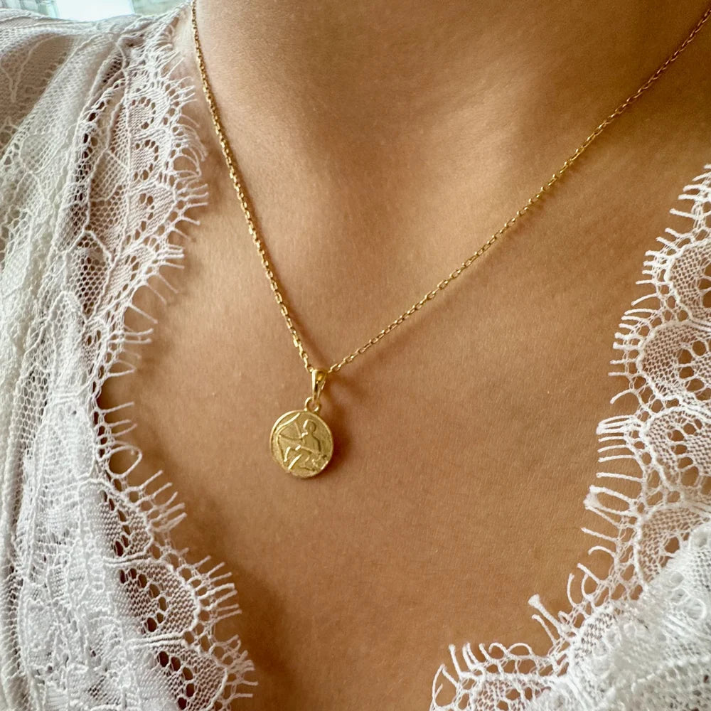 Delicate gold pendant necklace featuring an intricate design, perfect for women seeking a minimalist, chic style.