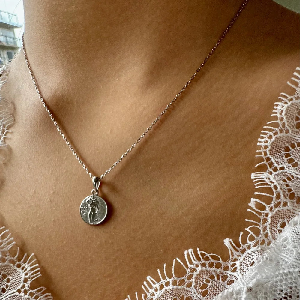 Sterling silver necklace featuring a minimalist coin pendant, perfect for women seeking a classic, elegant accessory.