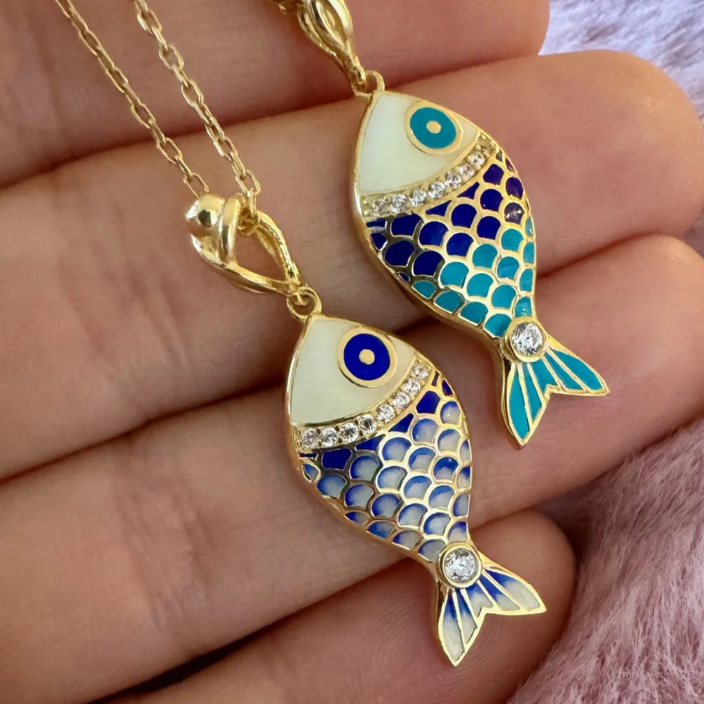 Gold fish pendant necklace featuring vibrant blue and turquoise enamel, perfect for stylish women and boho enthusiasts.