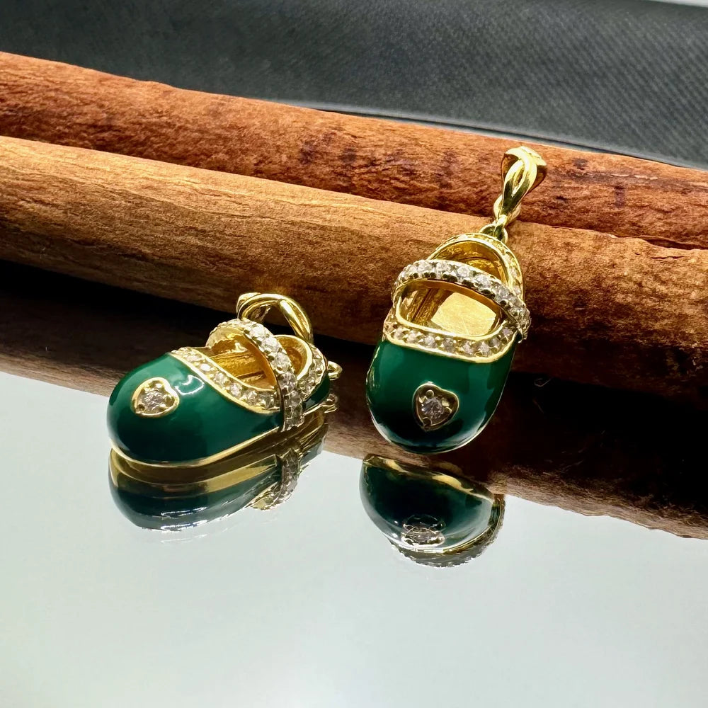 Gold baby shoe pendant and charm set with emerald-green enamel for women, perfect for a vintage or playful style.