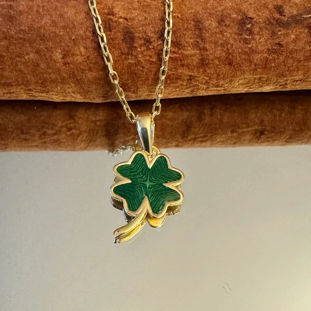 Gold four-leaf clover necklace with green enamel, perfect for women seeking a touch of luck and charm in a minimalist style.