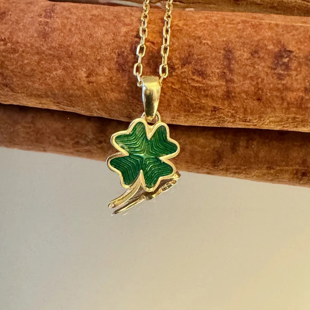 Gold clover pendant necklace with green enamel, perfect for women seeking a playful, vintage accessory for any occasion.