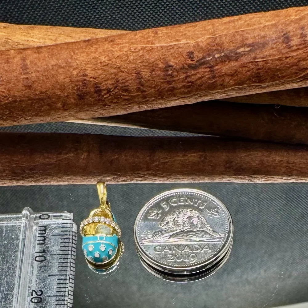 Gold charm pendant featuring turquoise accents, perfect for women seeking a playful, vintage touch in their jewelry collection.