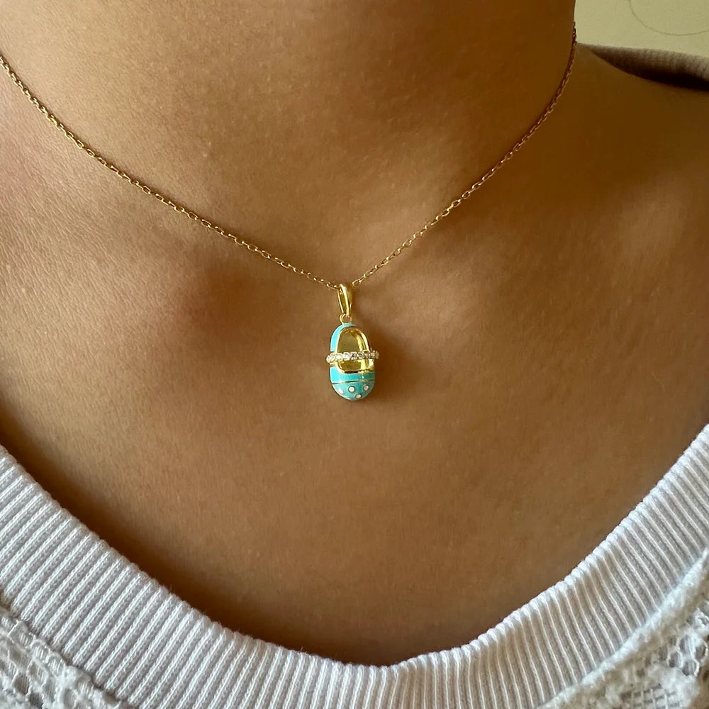 Gold necklace featuring a playful turquoise basket pendant, perfect for women seeking a trendy, whimsical style.