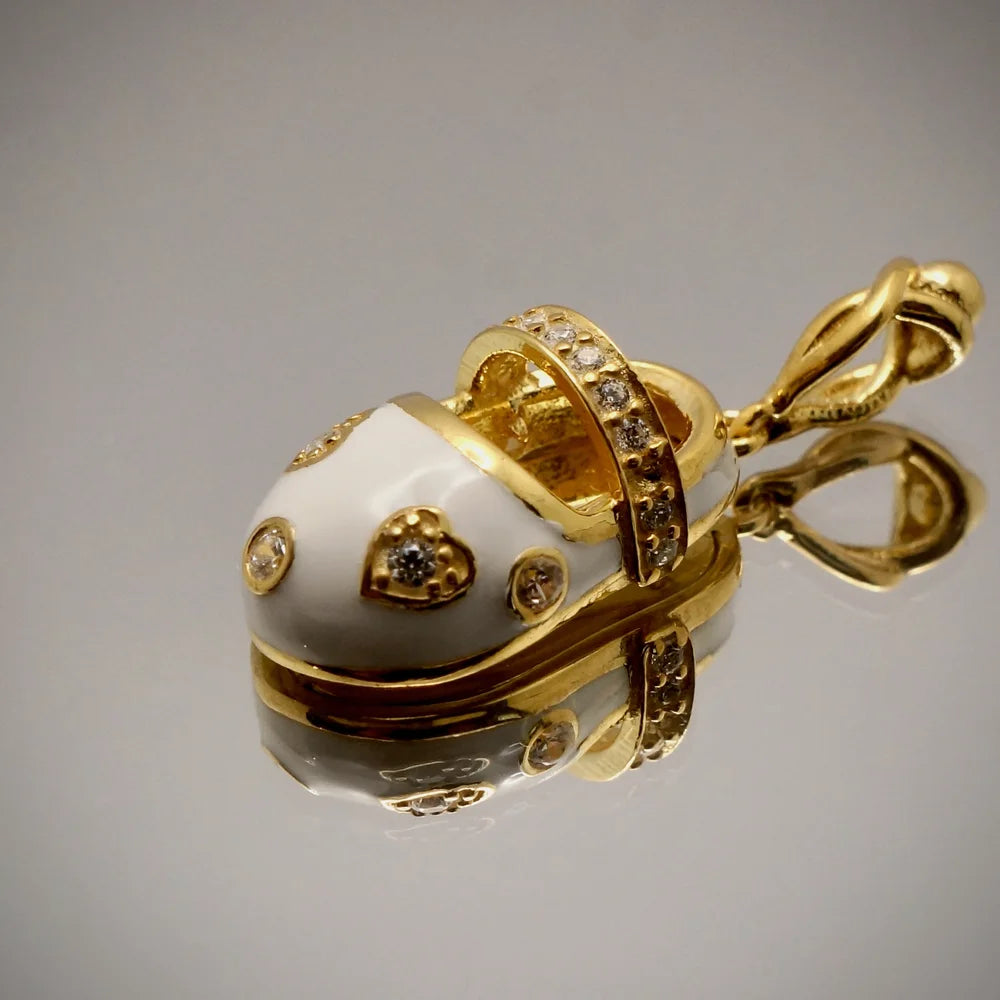 Gold baby shoe charm adorned with hearts and crystals, perfect for women seeking playful, vintage jewelry.