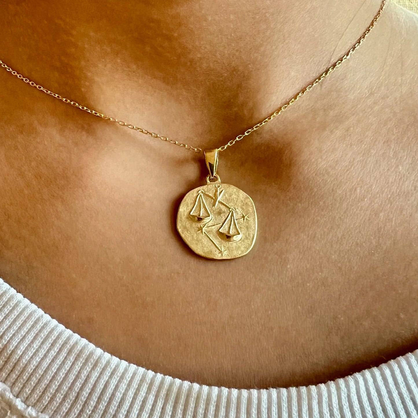 Gold zodiac pendant necklace featuring Libra scales, perfect for women seeking a unique, minimalist style.