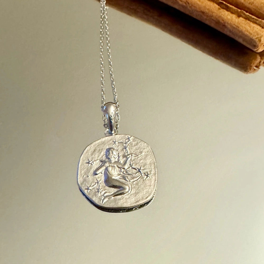 Silver charm necklace featuring a detailed celestial design, perfect for women who love vintage, artistic jewelry.