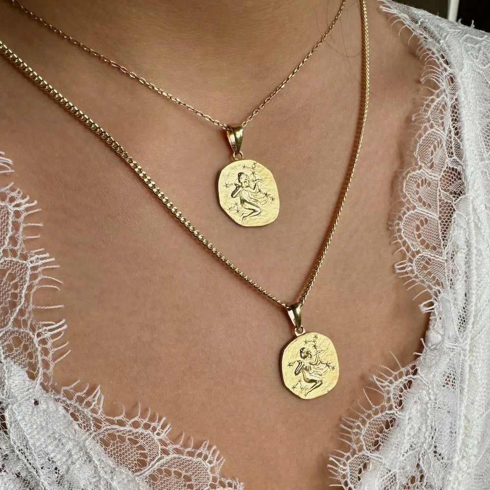 Elegant gold pendant necklace set featuring intricately designed charms, perfect for stylish women or trendy unisex wear.