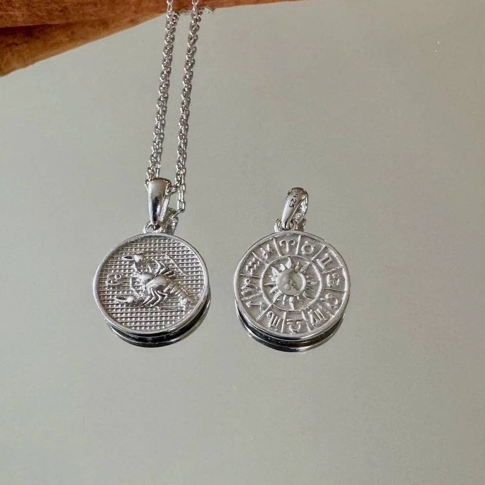 Silver zodiac charm necklace for women featuring dual pendants, perfect for astrology lovers and stylish layering.