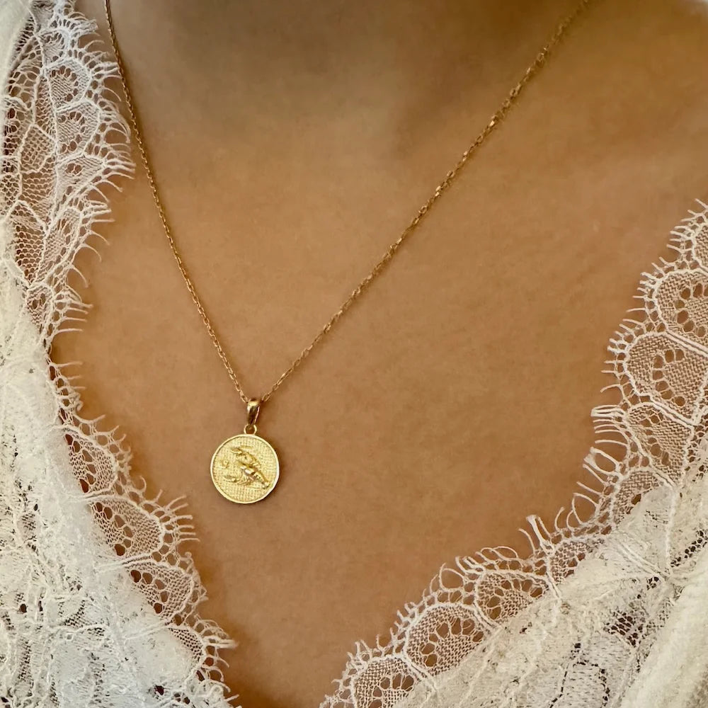 Gold coin pendant necklace on a minimalist chain, perfect for women; ideal for casual or elegant occasions.