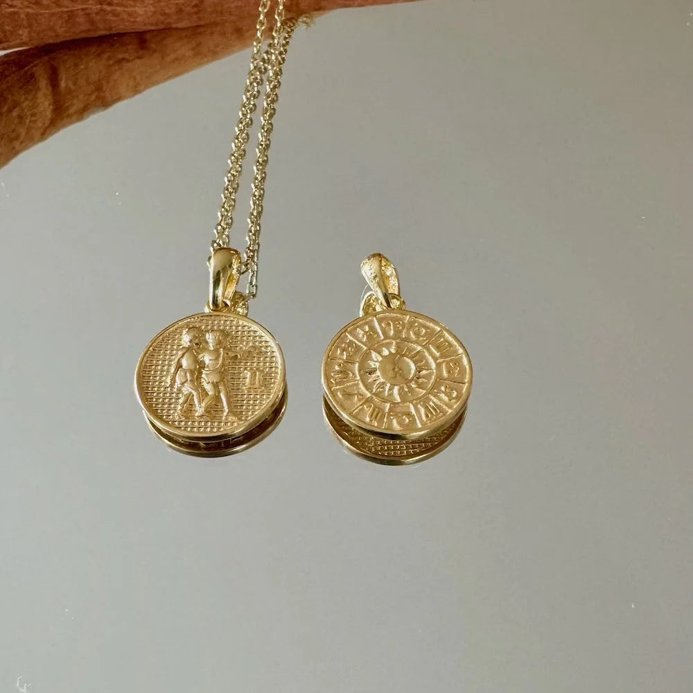 Gold zodiac pendant necklace with intricate designs, perfect for women seeking a unique, bohemian style accessory.