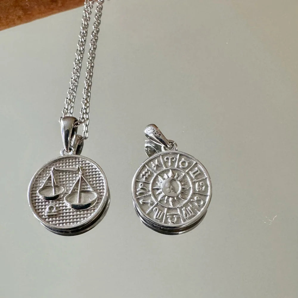 Sterling silver zodiac charm necklace featuring astrology symbols, perfect for women seeking a bohemian touch.
