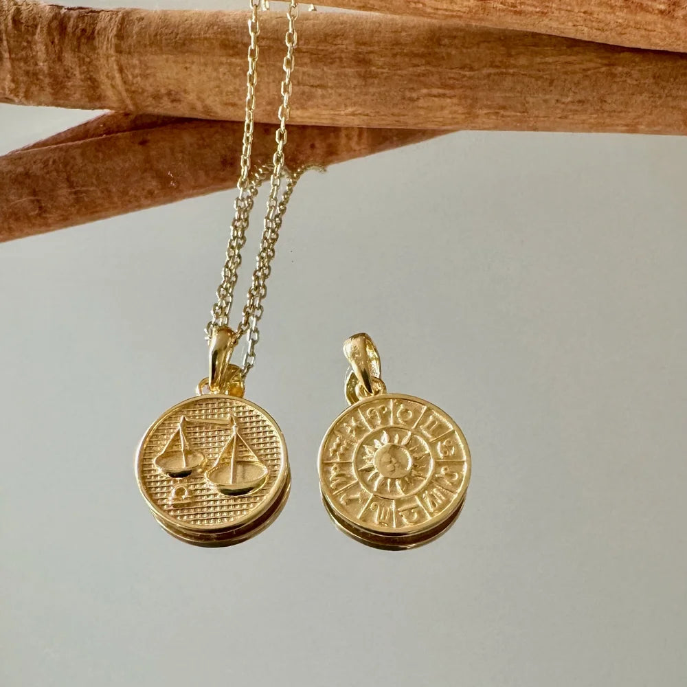 Gold zodiac pendant necklace with double-sided charms, perfect for women who love minimalistic and celestial jewelry.