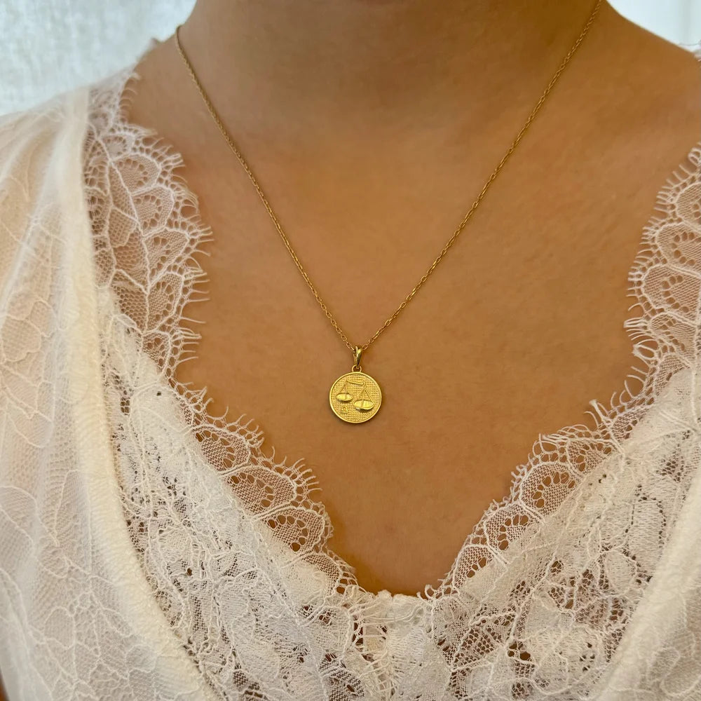 Gold Libra zodiac necklace on a delicate chain, perfect for women who appreciate minimalist, celestial jewelry.