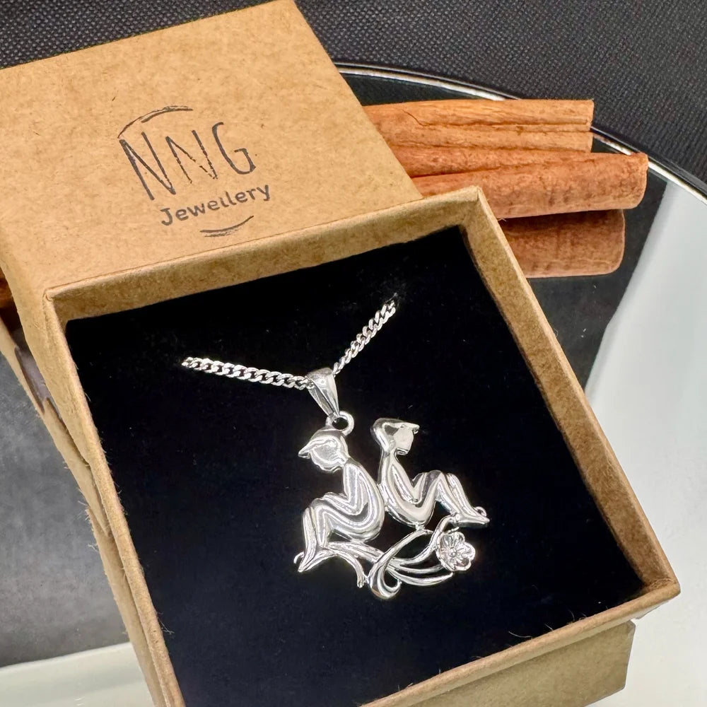 Sterling silver pendant featuring two playful figures, perfect for women seeking unique, whimsical jewelry.