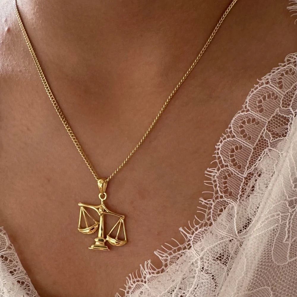 Golden scales of justice necklace, perfect for women who love minimalist jewelry; ideal for any occasion, stylish and meaningful.