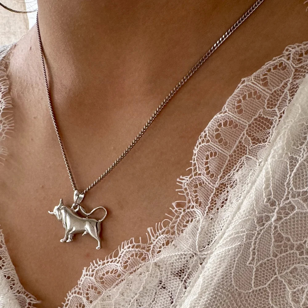 Silver cow pendant necklace on a delicate chain, perfect for women seeking a minimalist, unique accessory.