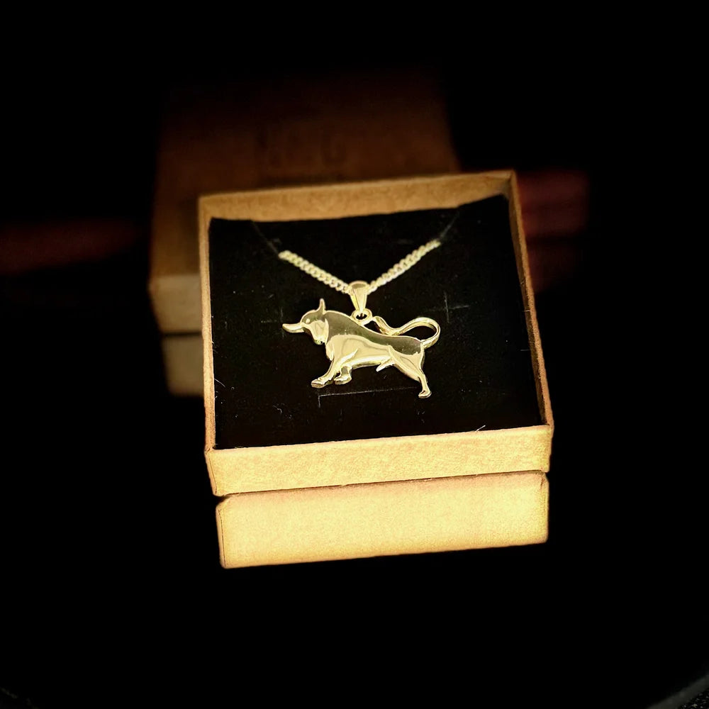 Gold bull pendant necklace on a silver chain, perfect for women who love unique, animal-themed jewelry.