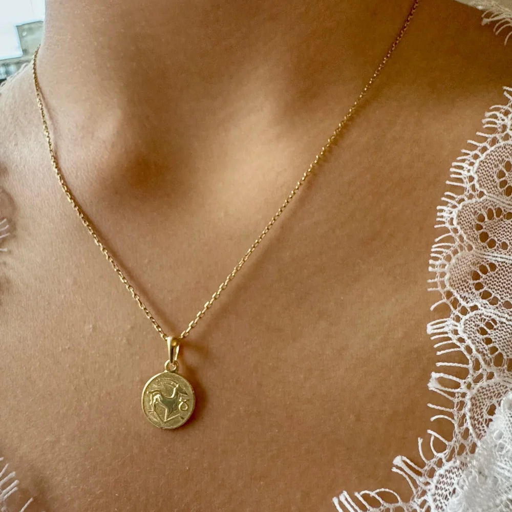 Gold pendant necklace with a detailed charm, perfect for women seeking a minimalist yet elegant accessory.