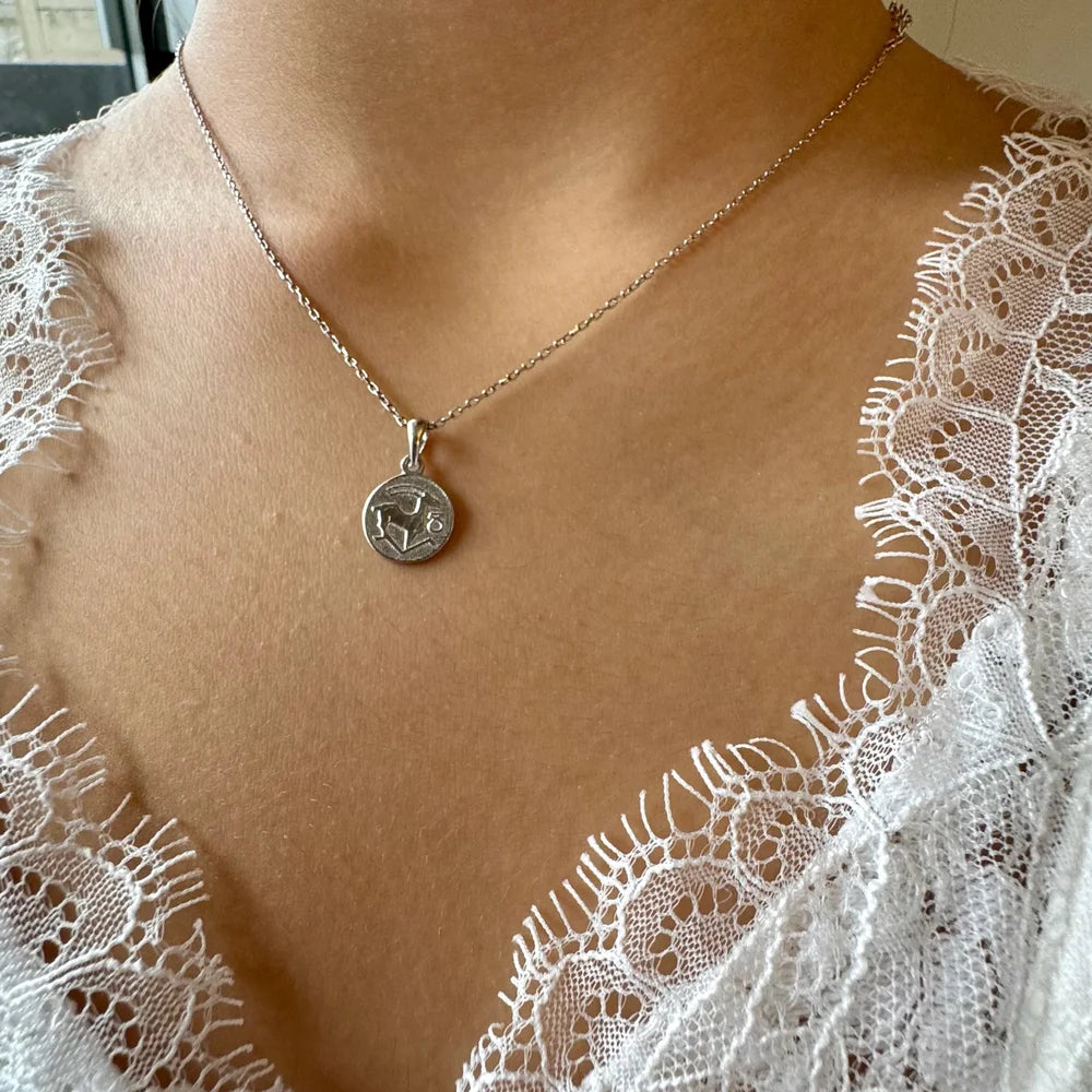 Sterling silver coin pendant necklace on a delicate chain, perfect for women seeking a minimalist vintage style.