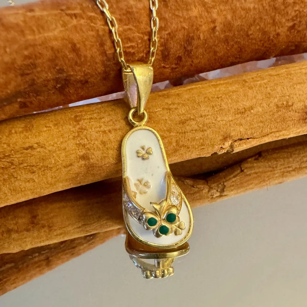 Gold shoe-shaped pendant necklace with emerald accents, perfect for women seeking a unique vintage look.