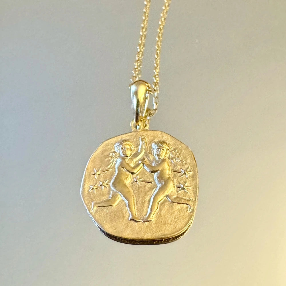 Gold Gemini zodiac pendant necklace with intricate twin design, perfect for women who love minimalist astrology jewelry.
