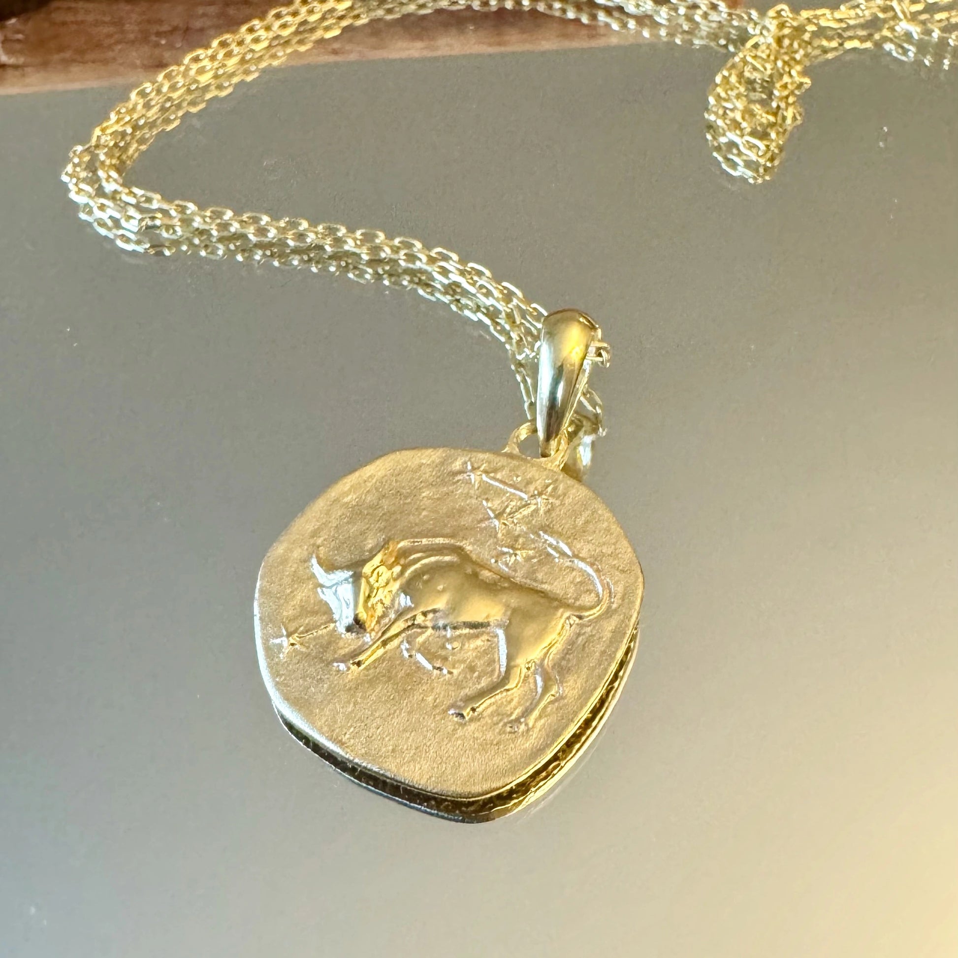 Elegant gold Taurus zodiac pendant necklace, perfect for women and men who appreciate minimalist astrology jewelry.